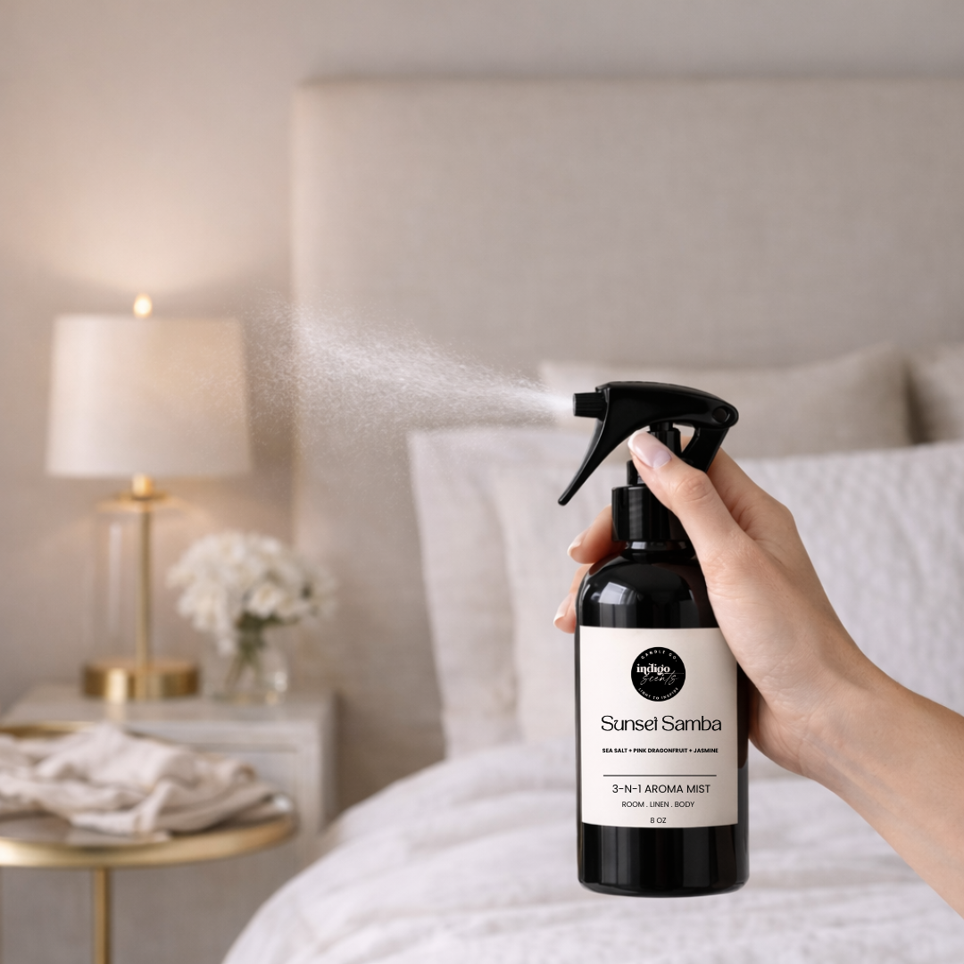Person holding a bottle of 'Sunset Samba' 3-in-1 Aroma Mist in a bedroom setting.