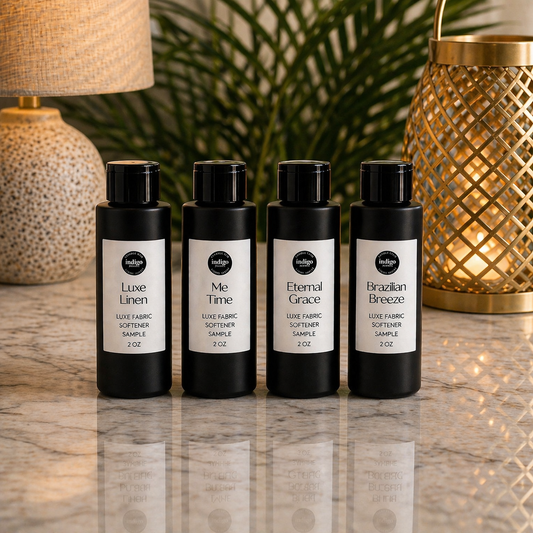 Four black bottles with labels on a reflective surface with decorative background