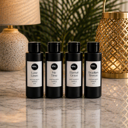 Four black mop majesty bottles with labels on a marble surface with decorative lamps and plants in the background.