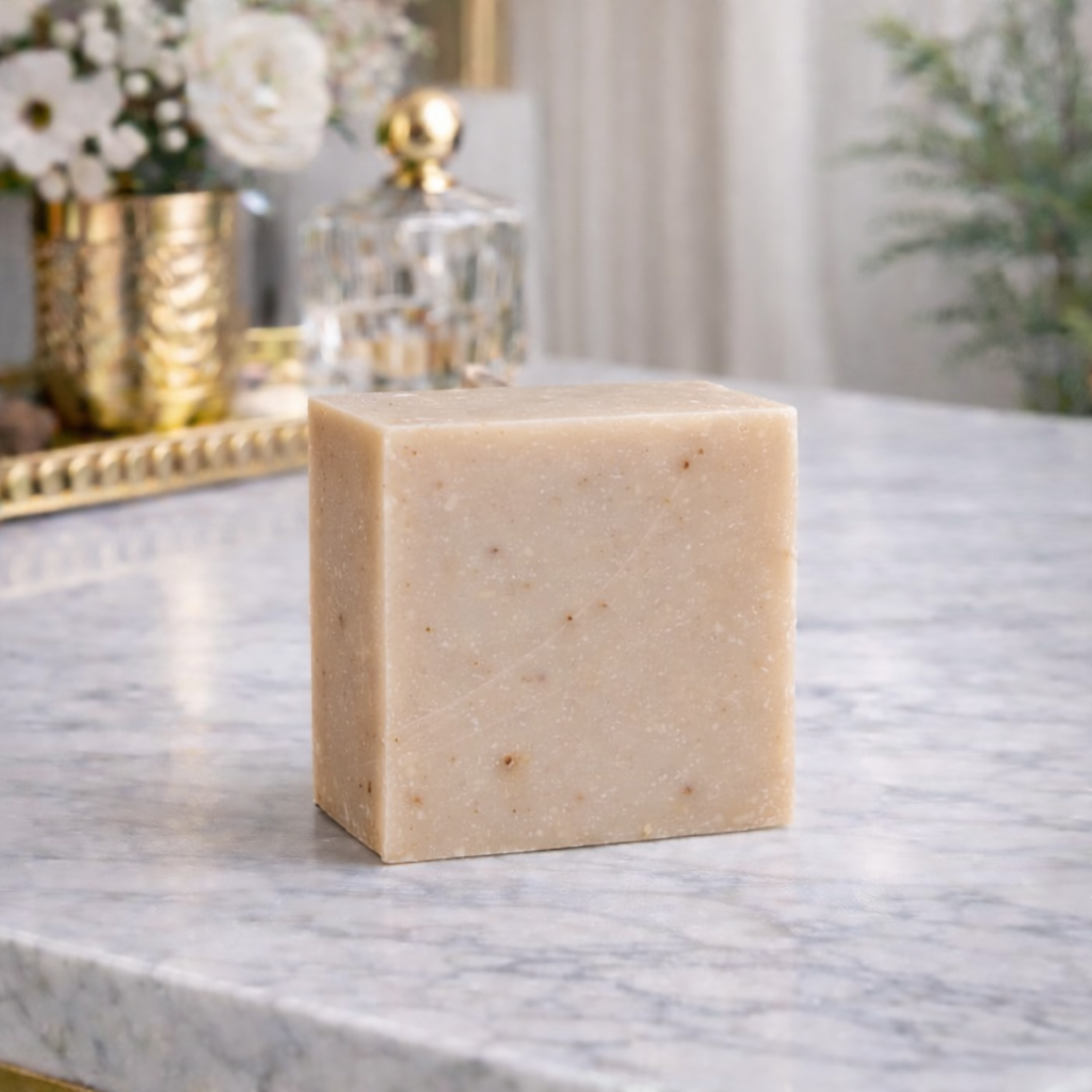Square bar of soap on a marble surface with decorative items in the background