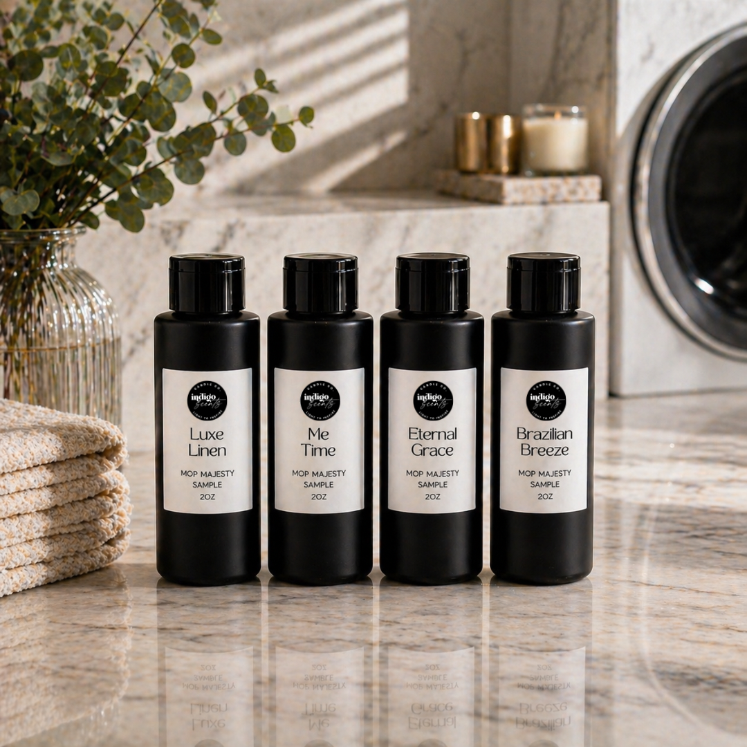 Four black bottles of Mop Majesty with labels on a bathroom counter, with candles and a plant in the background.